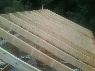 New roof rafters set over an addition before sheathing in Central City