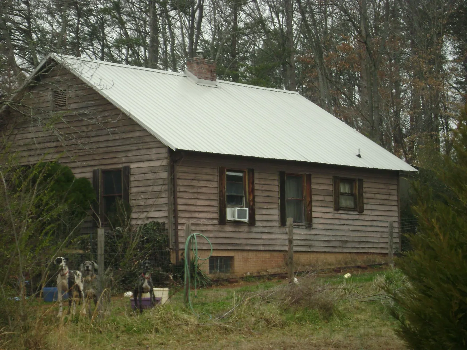 White metal roof on an old wood sided farmhouse, from a Metal Roof Installation job in Central City